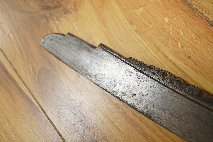 An elaborate Dayak headhunter’s sword Mandau, curved blade with chiselled and engraved back edge, large bone grip carved with protruding teeth, etc. in its wooden scabbard. Condition - good, some age wear.